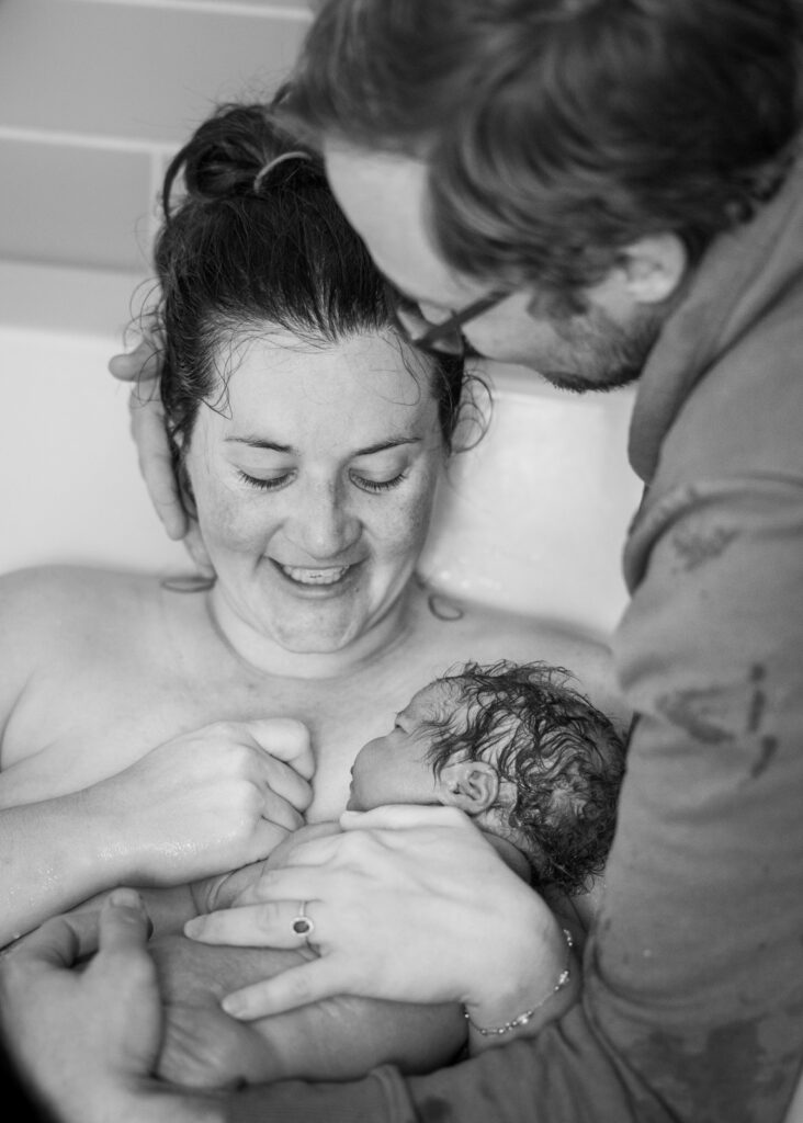 Greensboro Birth Photographer - Laboring mother in tub during home birth