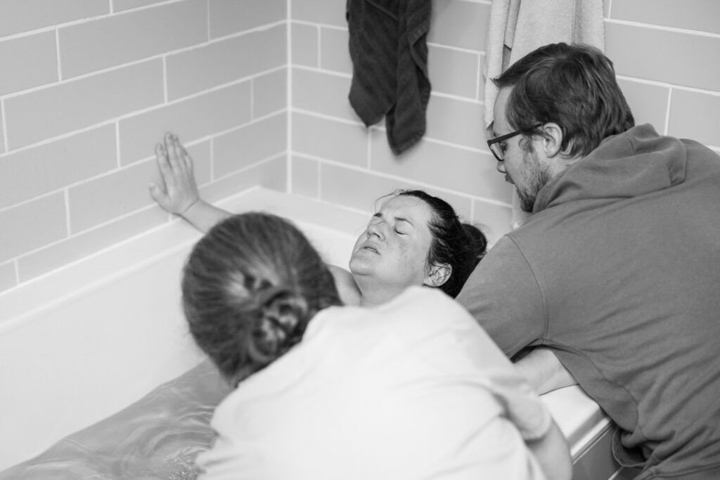 Greensboro Birth Photographer - Laboring mother in tub during home birth