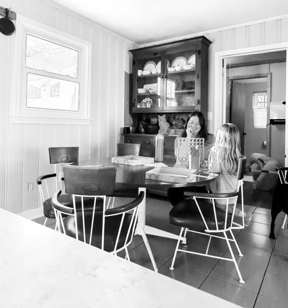 Greensboro Birth Photographer - Mother and daughter play a game at the kitchen table